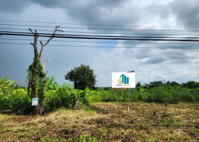 Vacant land with signage, partially cleared with some trees in view