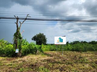 Vacant land with signage, partially cleared with some trees in view