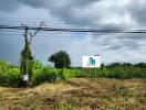 Vacant land with signage, partially cleared with some trees in view