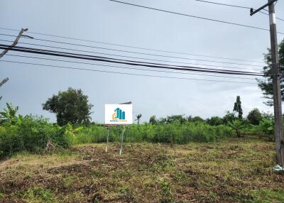 Open land with trees and a signboard