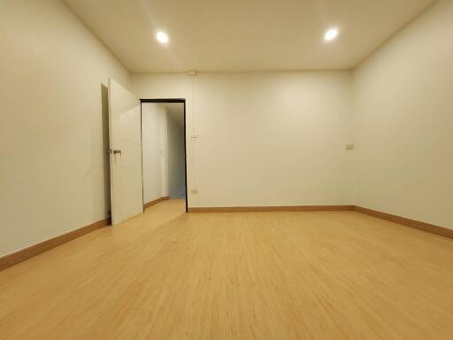 Empty room with wooden flooring and open door