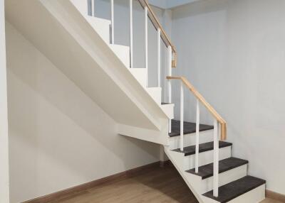 Staircase with wooden steps and handrail in a bright living area