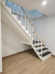 Staircase with wooden steps and handrail in a bright living area