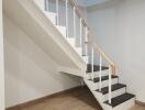 Staircase with wooden steps and handrail in a bright living area