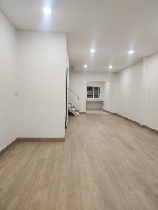 spacious living room with wooden flooring and staircase