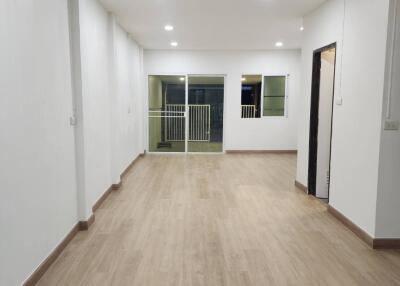 Spacious living area with wooden flooring and large windows