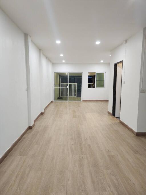 Spacious living area with wooden flooring and large windows