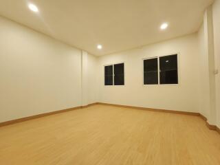 Spacious unfurnished living room with wooden flooring and recessed lighting