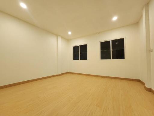 Spacious unfurnished living room with wooden flooring and recessed lighting