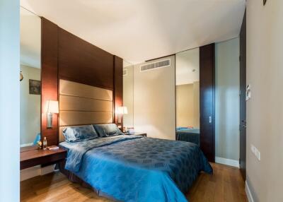 Modern bedroom with blue bedding and wooden accents