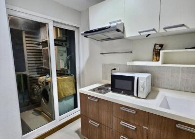 Modern compact kitchen with adjacent laundry area