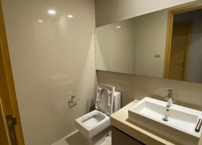 Modern bathroom with sink, toilet, and large mirror