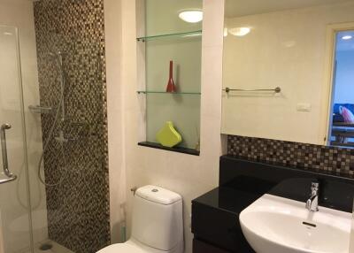 Modern bathroom with shower, toilet, sink, and decorative shelves