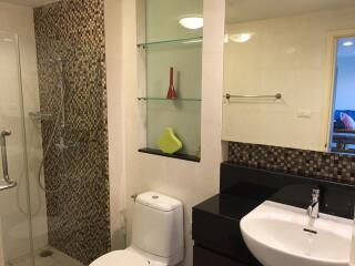 Modern bathroom with shower, toilet, sink, and decorative shelves