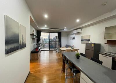 Open-concept living area with kitchen and dining, large windows