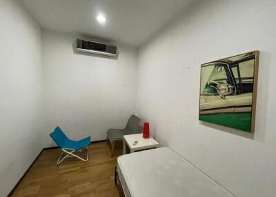 Small bedroom with a bed, chairs, and wall art