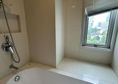 Modern bathroom with a soaking tub and city view window