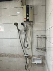 Bathroom shower area with water heater and accessories