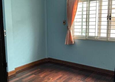 Empty bedroom with wooden floor and blue walls