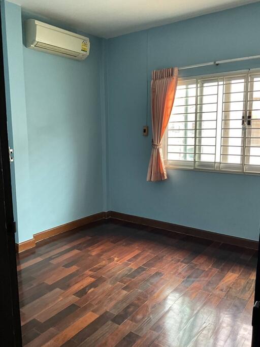 Empty bedroom with wooden floor and blue walls