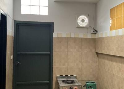 Photo of a kitchen with a stove, gas cylinder, and fire extinguisher