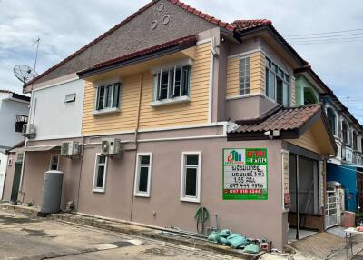 Exterior view of a two-story house with a signboard in front