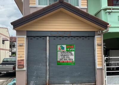 Two-story house with a garage and a for sale sign