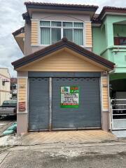 Two-story house with a garage and a for sale sign