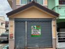 Two-story house with a garage and a for sale sign