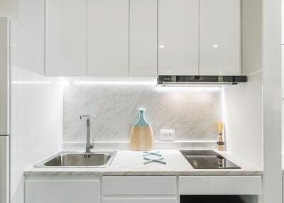 Modern kitchen with white cabinetry and marble countertops