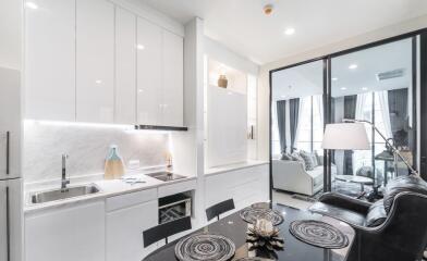 Modern kitchen with white cabinetry and living area