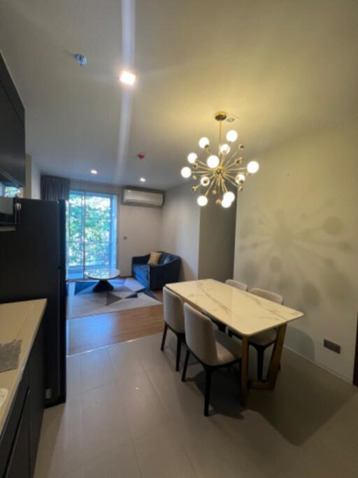 Modern living room and dining area with contemporary lighting and balcony