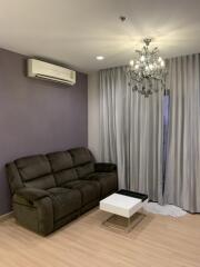 Living room with a brown sofa, modern coffee table, air conditioner, chandelier, and light curtains