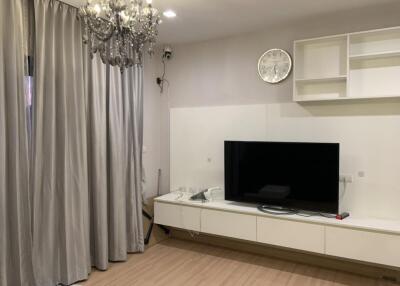 Modern living room with chandelier and wall-mounted TV