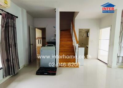 Living area with staircase and kitchen appliances