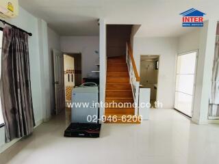 Living area with staircase and kitchen appliances