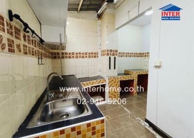 A compact kitchen with tiled walls and counters