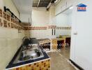 A compact kitchen with tiled walls and counters