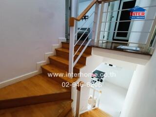 Interior staircase with wooden steps and a white railing