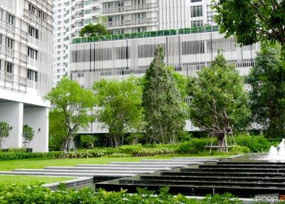 Modern building surrounded by greenery with a fountain