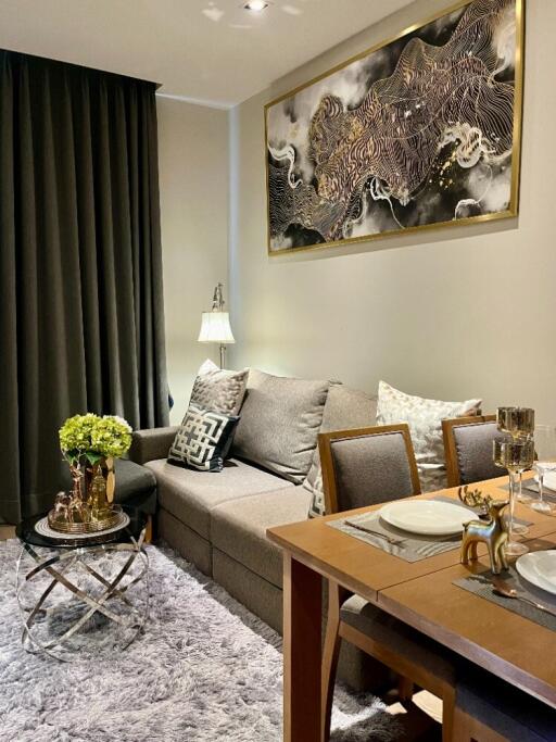 Living room with sofa, coffee table, dining area, and wall art