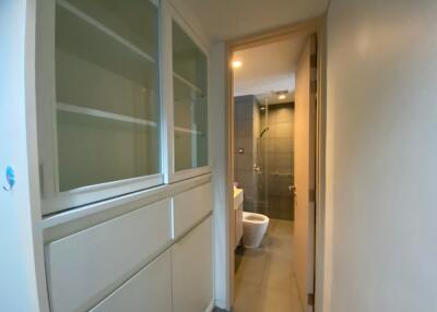 Hallway leading to bathroom with visible toilet and shower