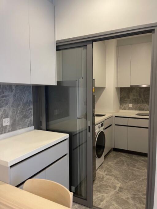 Modern kitchen with integrated washer-dryer and sleek cabinets