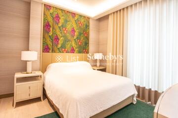 Bedroom with a double bed, side tables, and decorative greenery-themed wallpaper