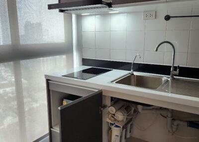 Modern kitchen with sink, cabinets, and induction stove