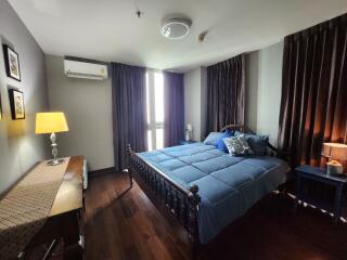 Cozy bedroom with blue bedding and wooden furniture