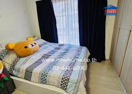 Bedroom with bed and stuffed bear pillow