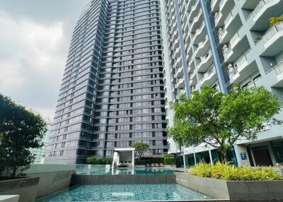 View of modern high-rise residential buildings with swimming pool and greenery