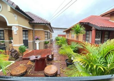 outdoor seating area between two houses with plants and decorative elements