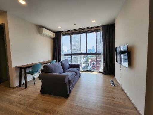 Modern living room with sofa, TV, and large windows